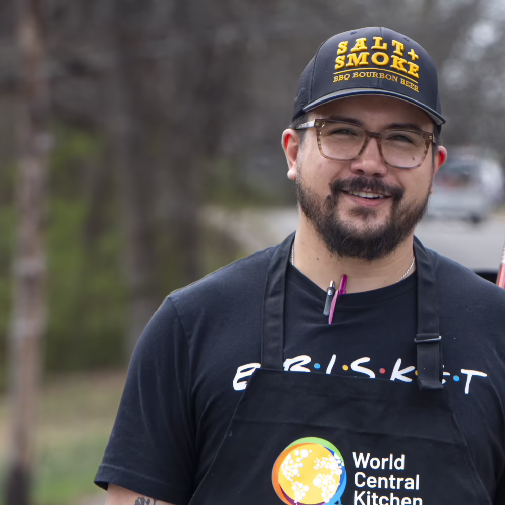 Man in apron near food truck.