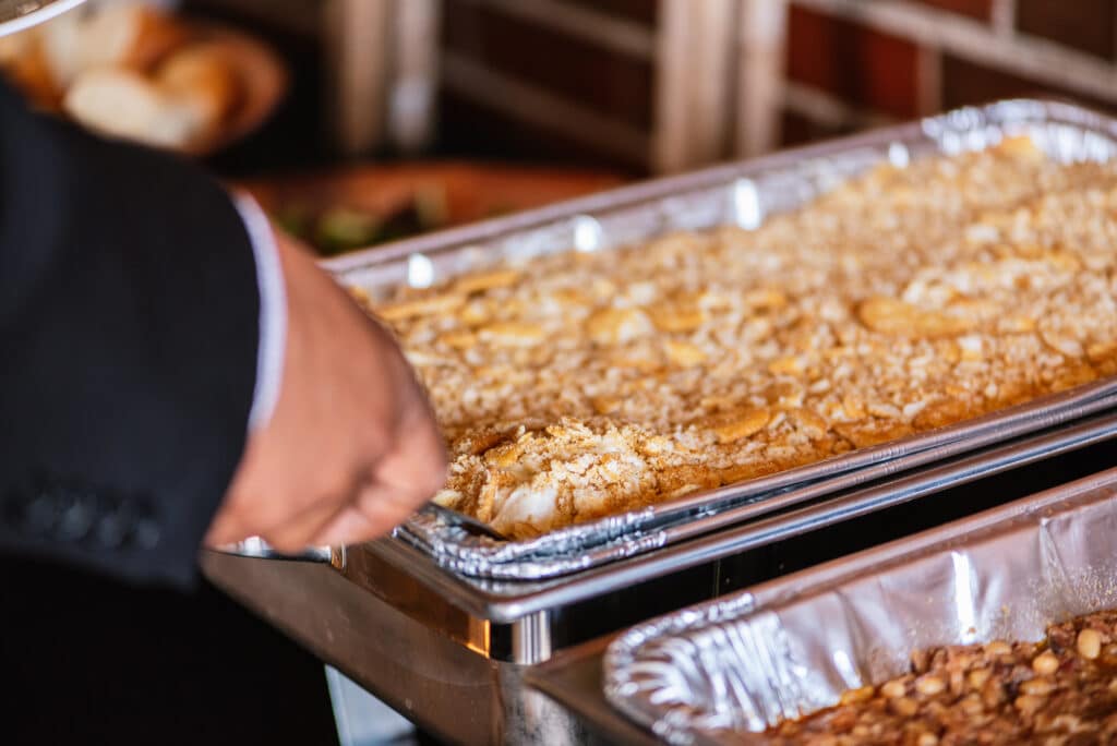 How to Choose the Right BBQ Catering Company for Your St. Louis Event 3 Person serving mac n cheese from tray