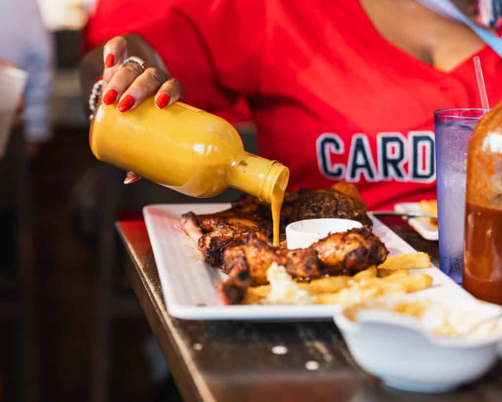 Where to Eat Near Busch Stadium on Game Day 3 Pouring sauce over grilled wings inside a restaurant near busch stadium