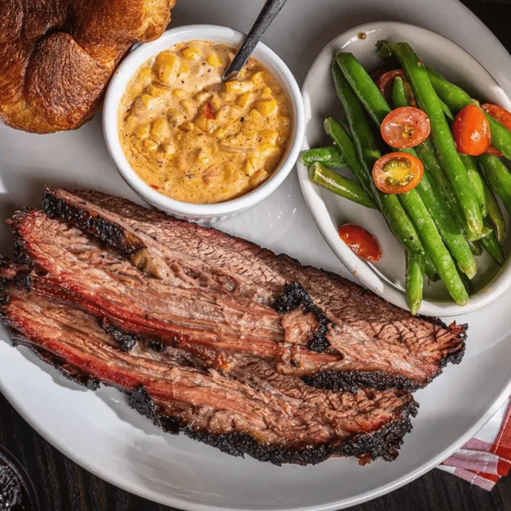 brisket, mac n cheese, and green beans on top of a table