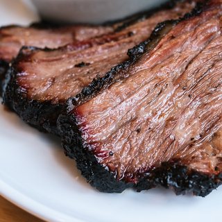 Sliced smoked brisket with a dark peppery bark