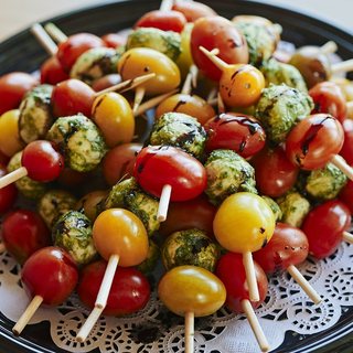 Skewers of cherry tomato, pesto-coated mozzarella and basil