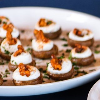 Mushroom caps filled with goat cheese and topped with walnuts