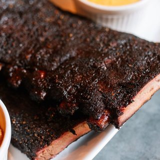 A slab of smoked pork ribs with a dark bark