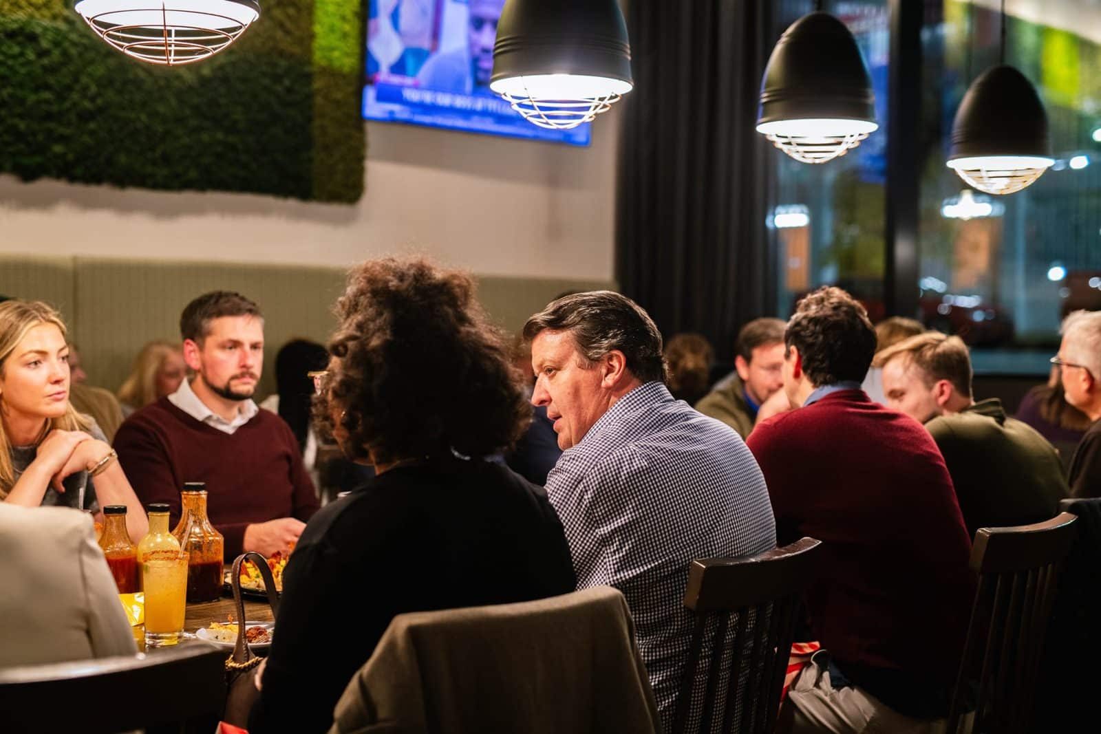 A table of friends talking over drinks and BBQ at Salt + Smoke
